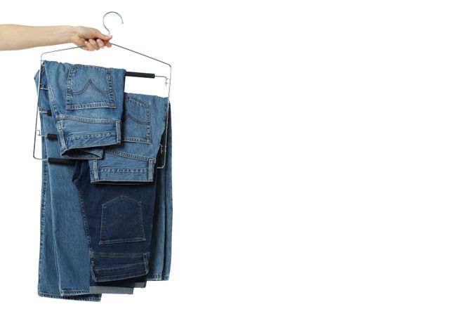 Jeans on hangers, isolated on light background
