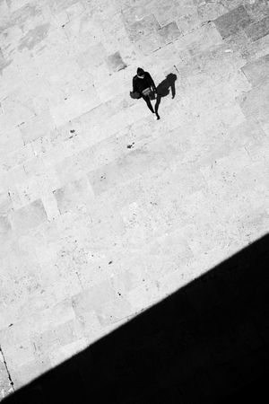 Looking down at woman and shadow walking in the sun