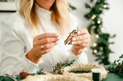 Woman crafting Christmas wreath at home