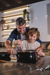 Father and son cooking in kitchen together