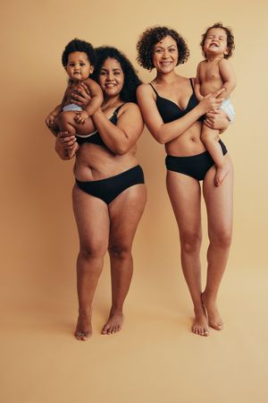 Joyful new moms embracing their postpartum bodies