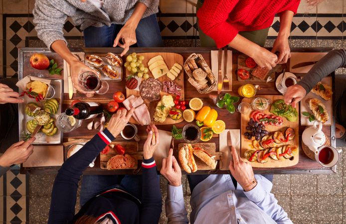 Faceless friends enjoying festive food at table