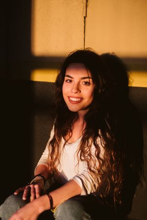 Smiling woman sitting in spot of light
