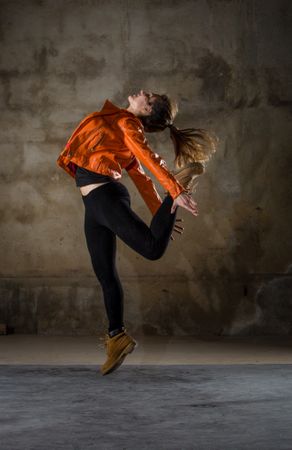 Young woman jumping in grey room