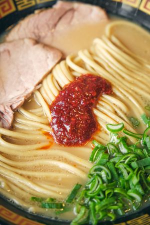 Tasty ramen with tomato salsa on noodles in broth