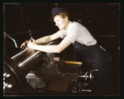 Milwaukee, WI, USA - 1943: Woman leaning over gun manufacturing machinery