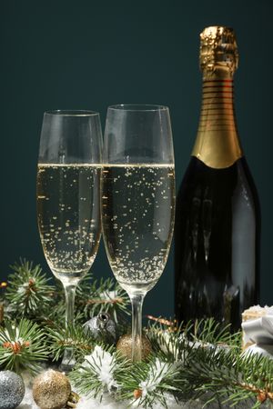 Champagne glasses and bottle on decorated background, close up