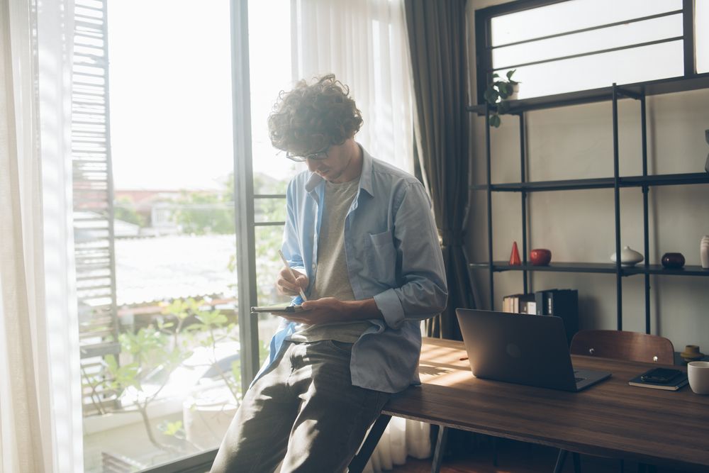 Creative designer writing on digital tablet working at home