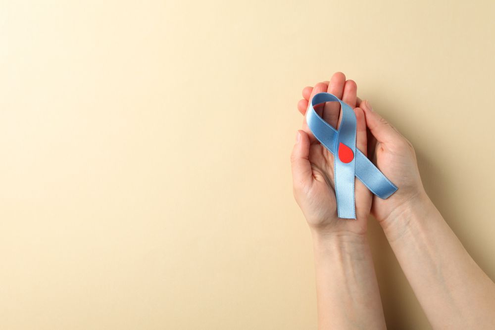 Female hands hold diabetes awareness ribbon on beige background