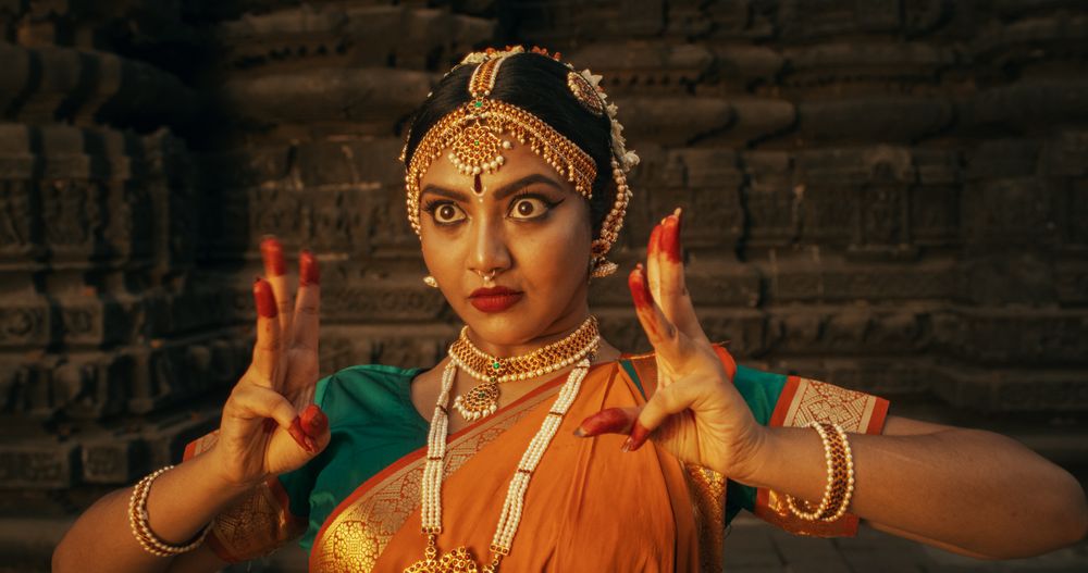 Portrait of Lively Indian Woman Wearing Traditional Clothes, Dancing Bharatanatyam with Expressive Face and Swift Moves.