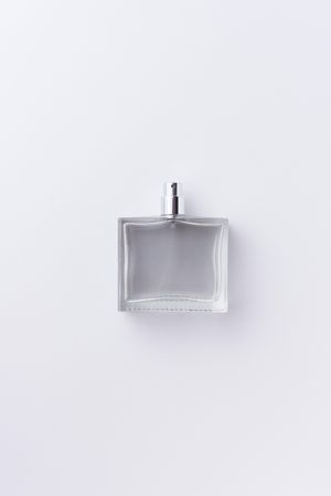 Clear perfume over pale background