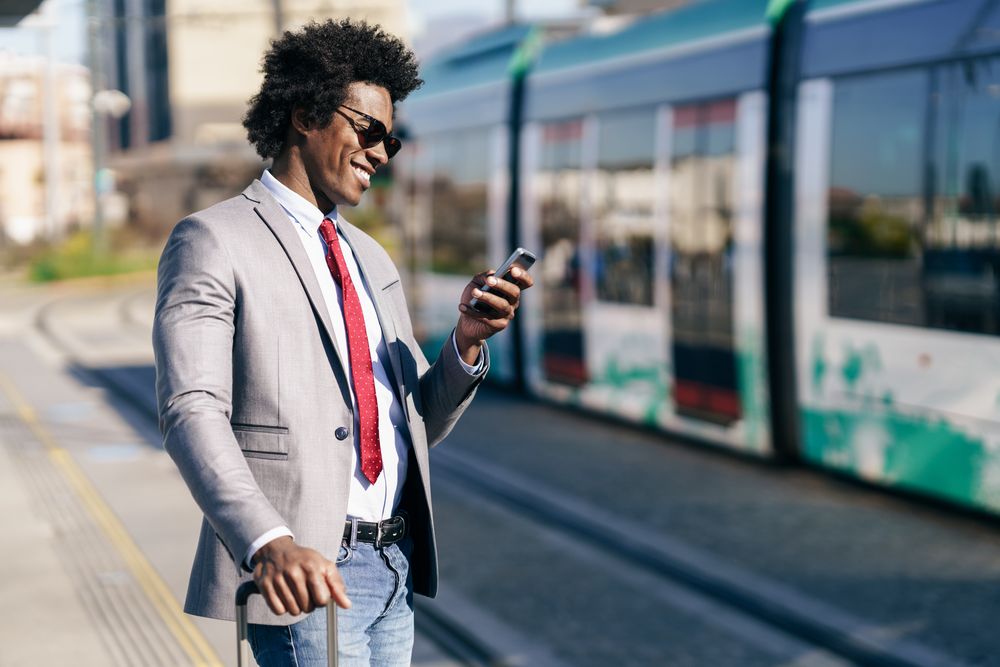 Man in jeans and dress shirt with tie at train station