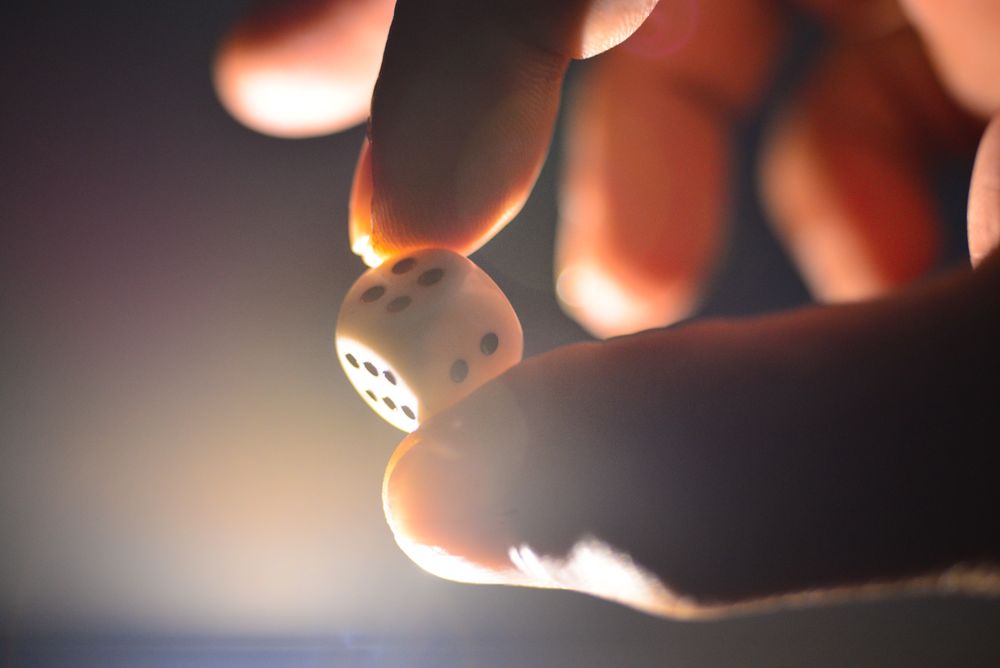 Hand holding a die with back lighting