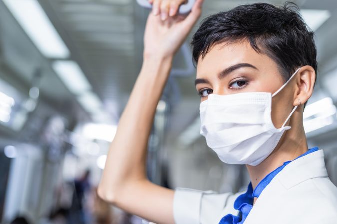 Woman in facemask standing in metro train