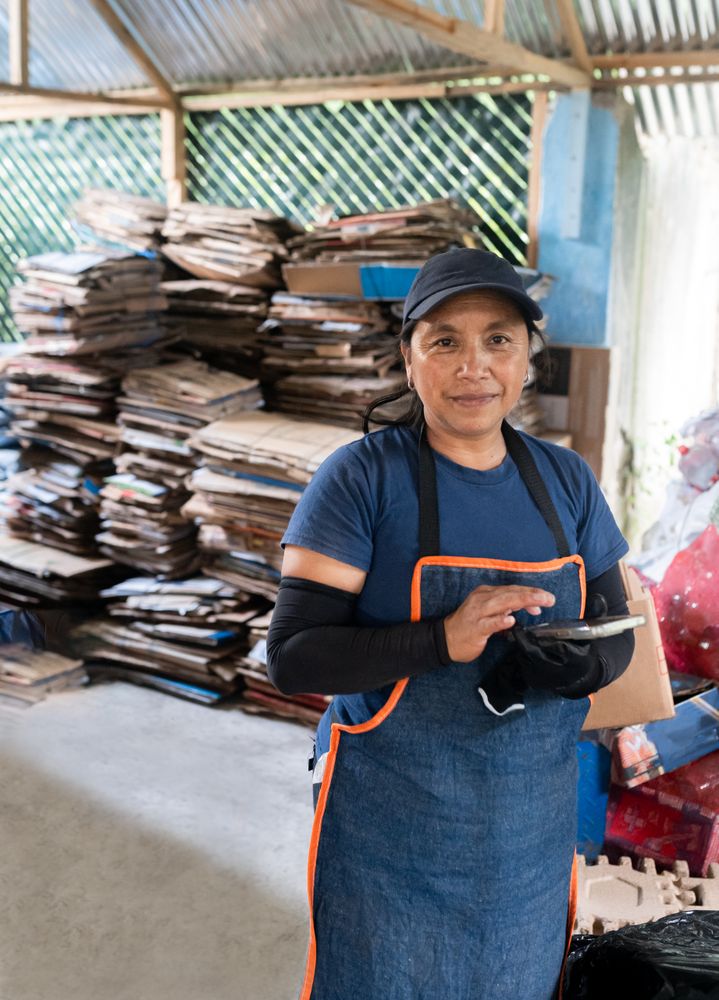 Portrait of an Adult Hispanic Woman Recording Recycling Data On Phone