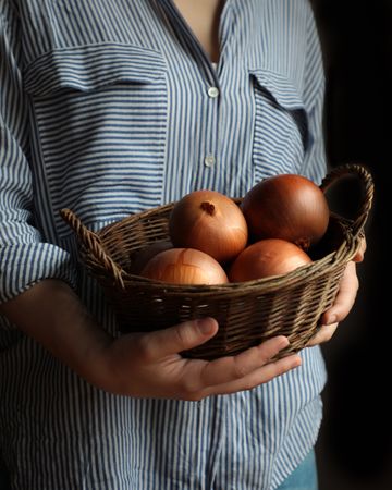 Round ripe onions in brown wicker basket
