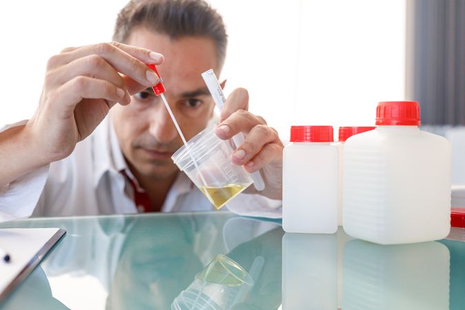 Male assistant using medical device for urine test