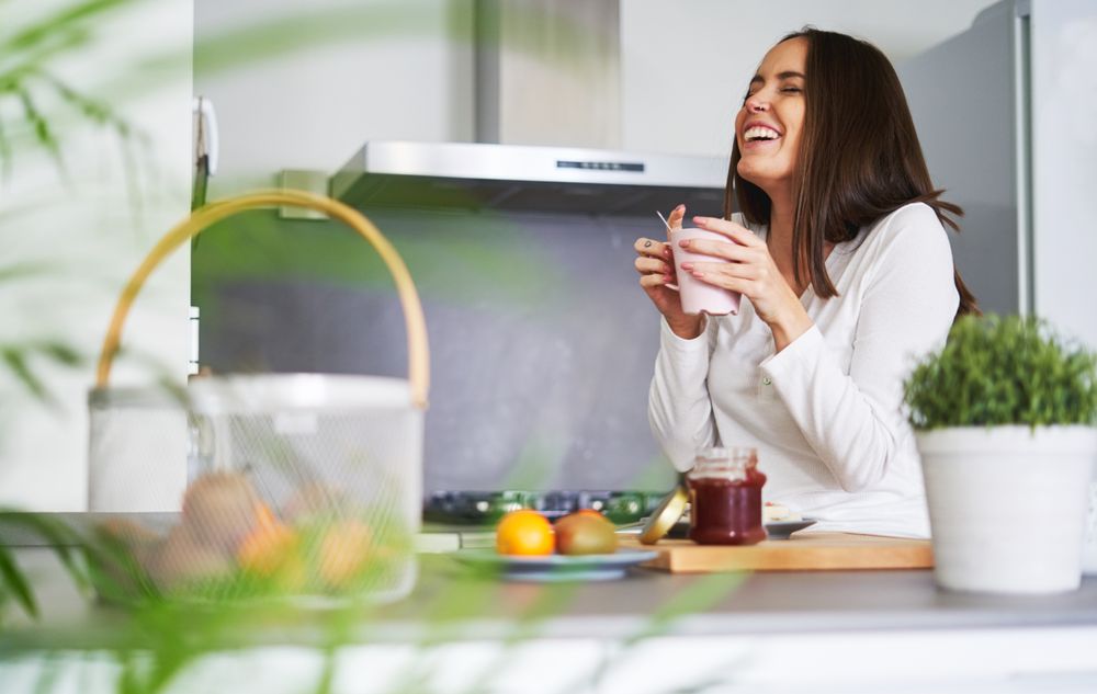 Woman drinking from cup in kitchen
