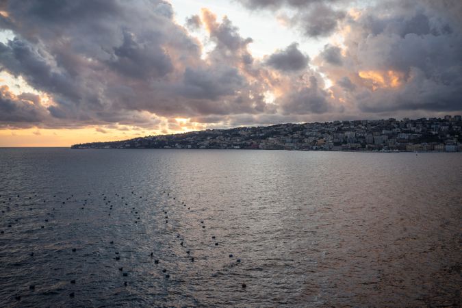 Landscape of calm sea and big city ob shore and beautiful cloudy sky