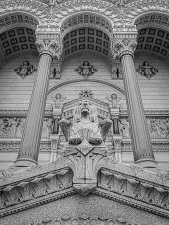 Winged lion between stone pillars and under arches