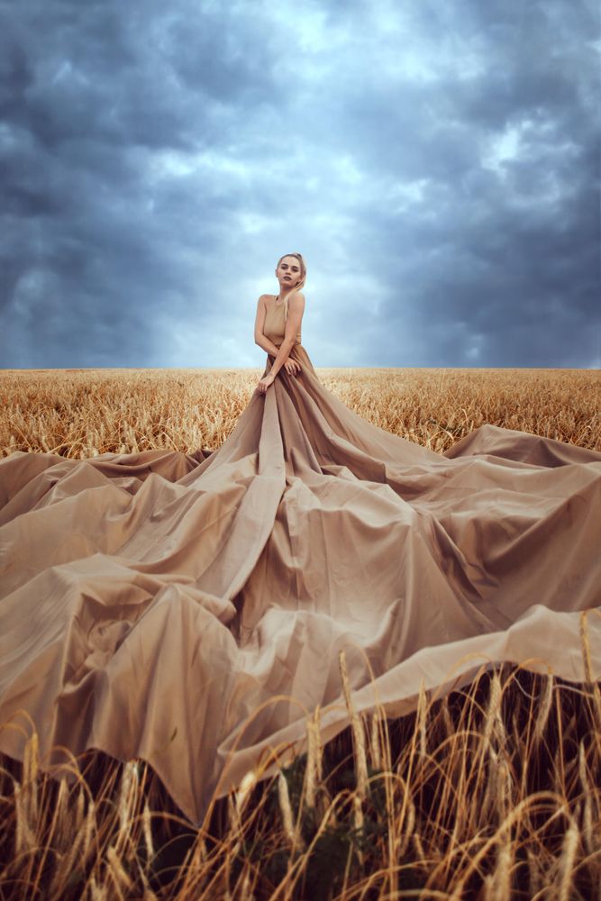 Woman in big brown dress in wheat field during daytime