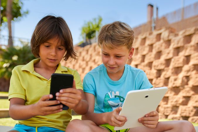Boys using tablet in garden