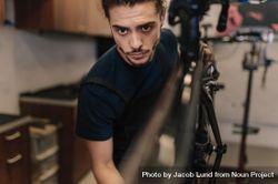Closeup of a man working on a bicycle in a repair shop 4mmVo4