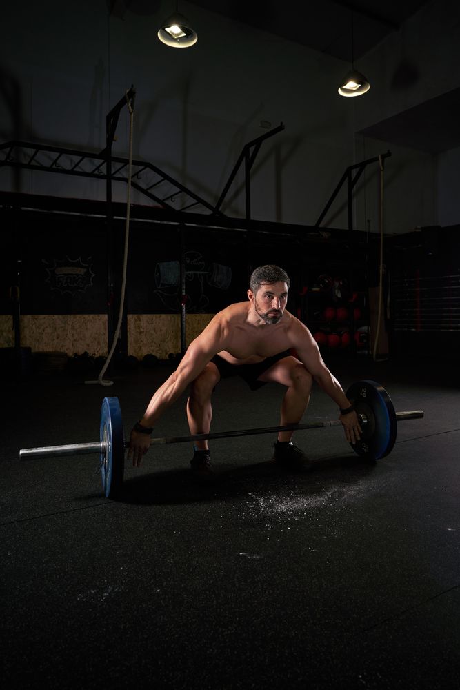 Strong concentrated man training with barbell