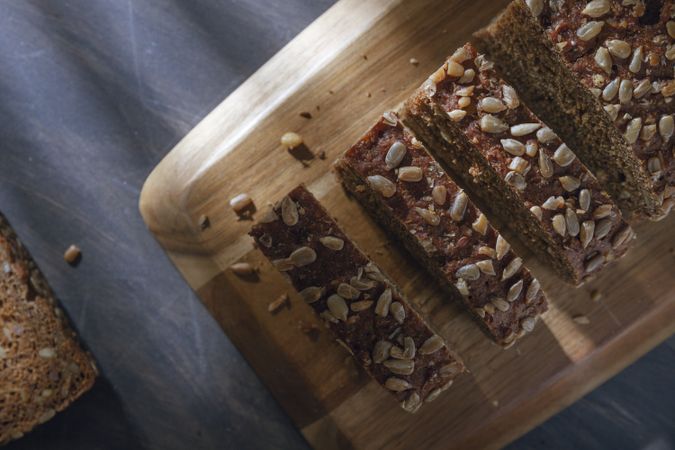 Sliced wholegrain bread on wooden cutting board