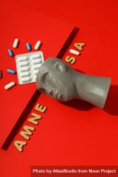 Model of bust with pills on red background and the words “Amnesia,” vertical composition 0VkNN5