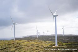 Wind turbines on green grass field under cloudy sky 4MJBkb