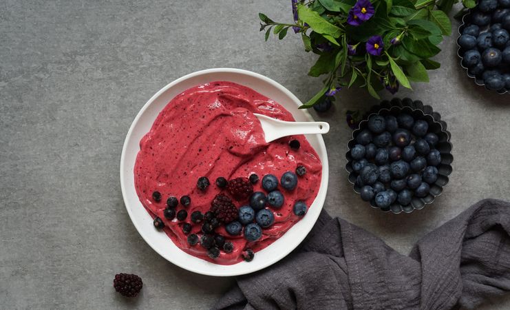 Smoothy of fresh bog blueberries and raspberries in bowl near napkin