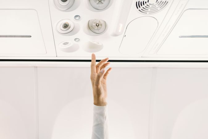 Person pressing button on panel up airplane