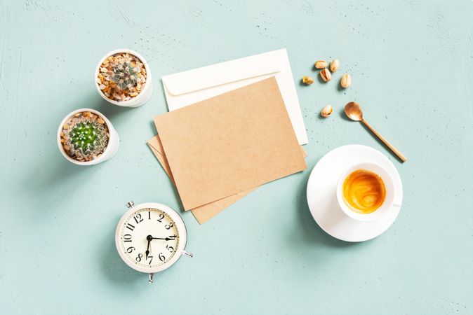 Espresso, card and succulents and clock on baby blue background
