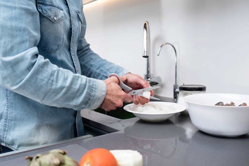 Cropped shot of man cutting seafood with scissors