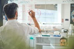 Unrecognizable man working at laboratory with scheme