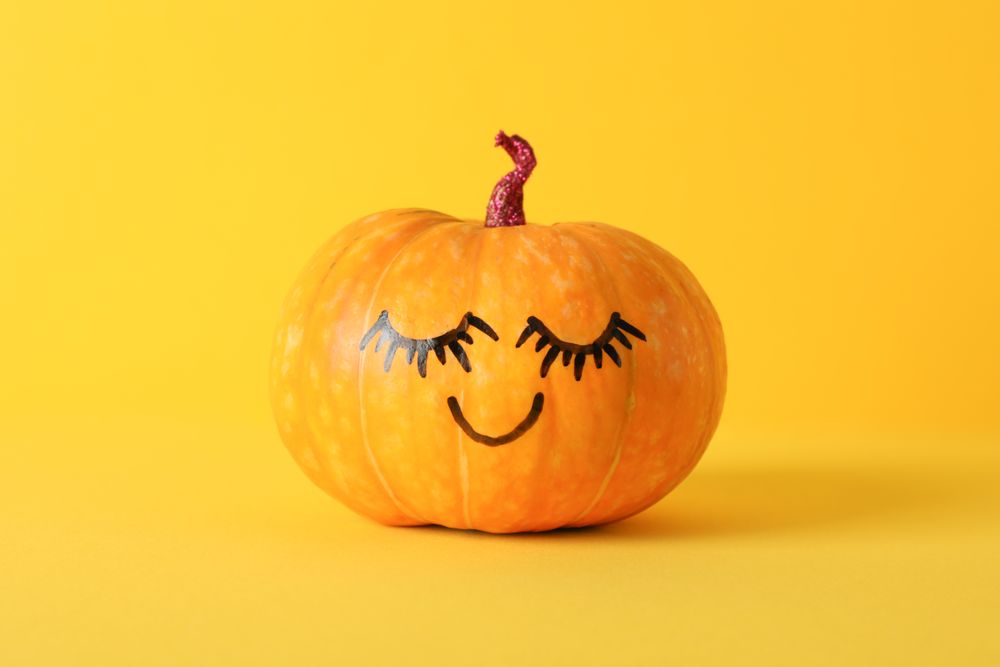 Pumpkin with smile on yellow background, space for text