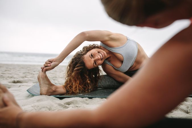 Women stretching at yoga class and sitting near the sea