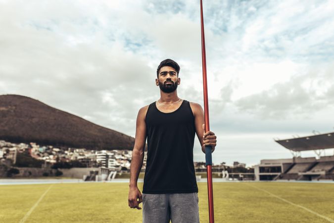 Athlete standing in a track and field stadium holding a javelin