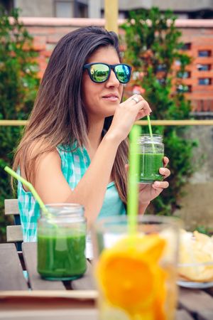 Woman in sunglasses sitting in backyard with drinks