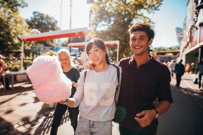 Young people with cotton candy at amusement park