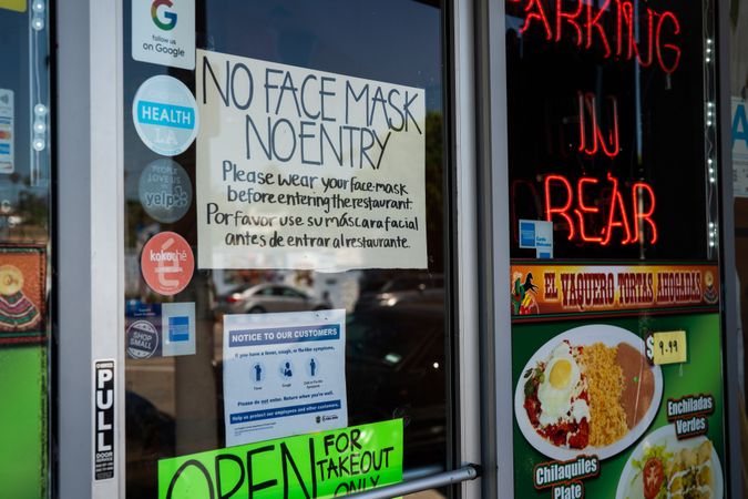Social distancing signs in window of Mexican restaurant