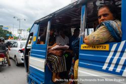 Adult Indian woman looking out of cramped transit bus in traffic in Dehradun, India 5ngAZ4