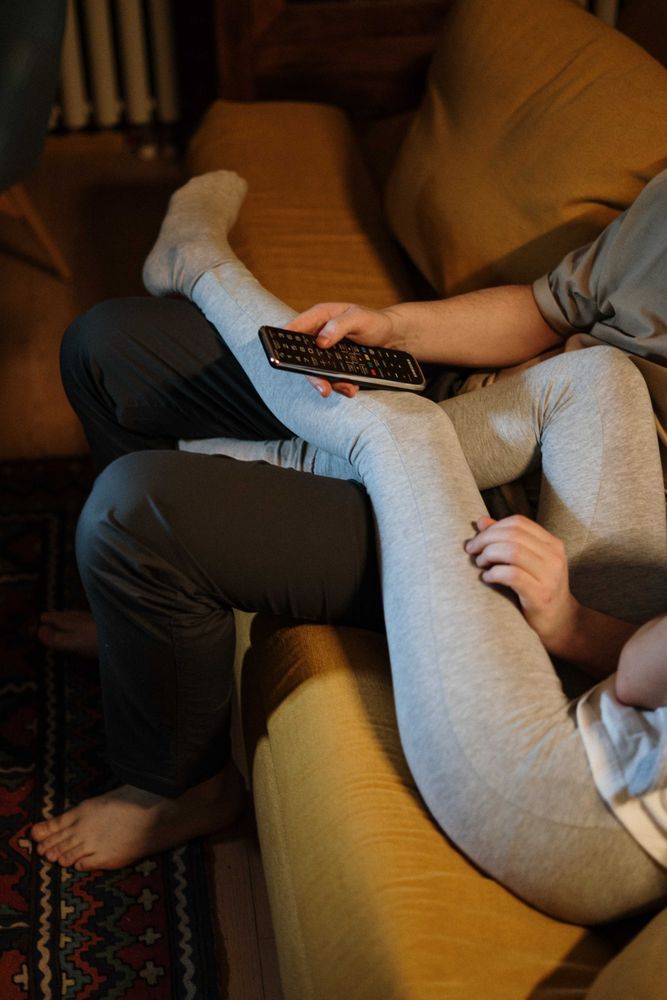 Cropped image of couple chilling on couch and watching tv