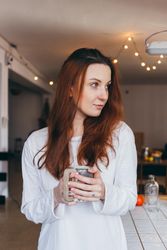Woman with a mug of a warm drink in her apartment