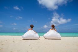 Anonymous couple relaxing on sandy beach