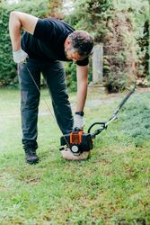 Man switching on a mechanical garden tool