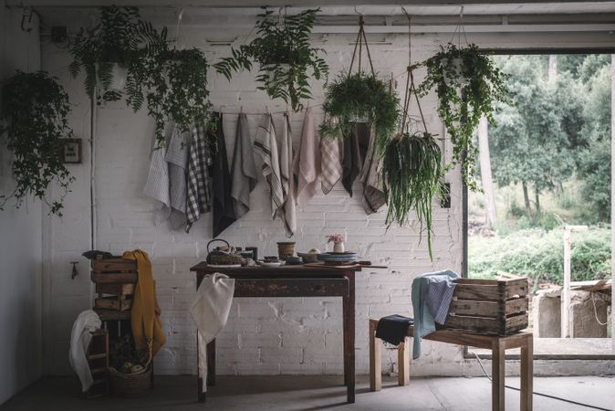 Table with flowers in vase on trays near towels hanging on thread