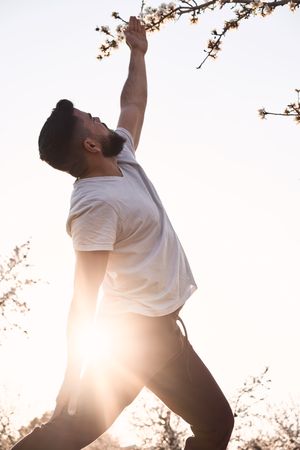 Man doing yoga in spring garden