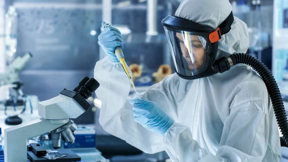 Medical Virology Research Scientist Works in a Hazmat Suit with Mask